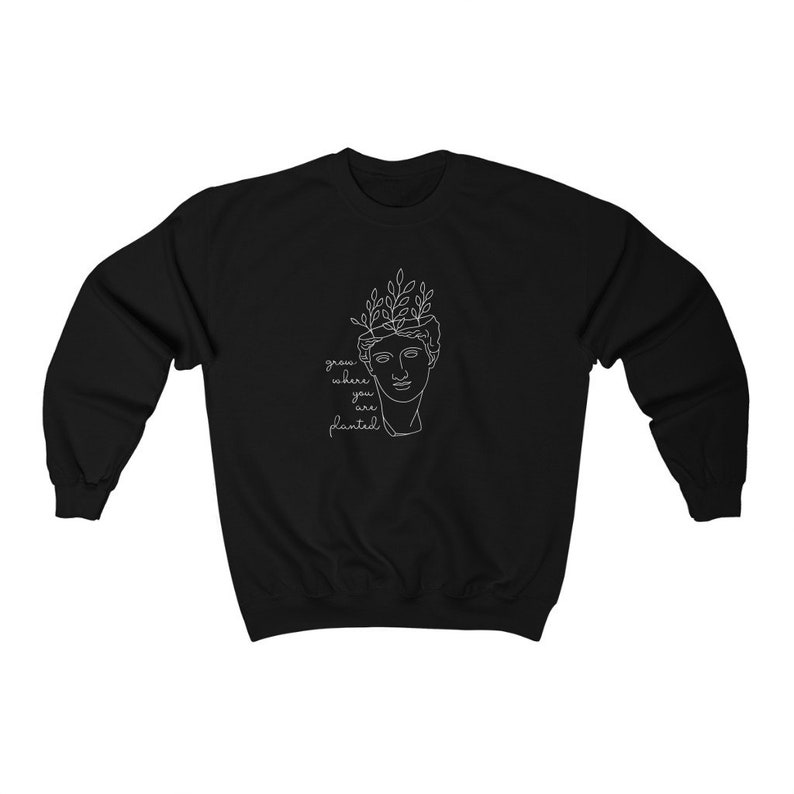 May include: Black sweatshirt with a white line drawing of a bust with leaves growing from the top. The text "grow where you are planted" is below the bust.
