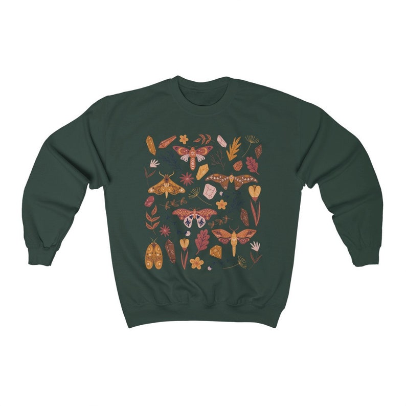 Puede incluir: Una sudadera verde oscuro con un patr&oacute;n colorido de polillas, cristales y flores. Las polillas son de varios tonos de naranja, marr&oacute;n y rosa.
