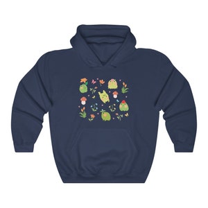 May include: Navy blue hooded sweatshirt with a pattern of green frogs, flowers, and mushrooms.