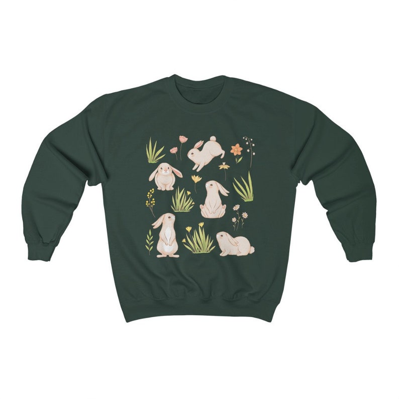 May include: A dark green sweatshirt with a white bunny rabbit pattern. The bunnies are surrounded by small flowers and green grass.