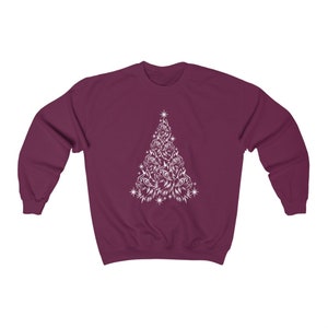 May include: A maroon sweatshirt featuring a white design of a Christmas tree made up of cat faces.