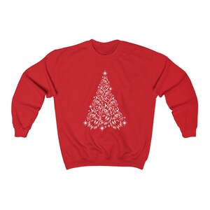 May include: Red sweatshirt with a white Christmas tree design made of cat faces.