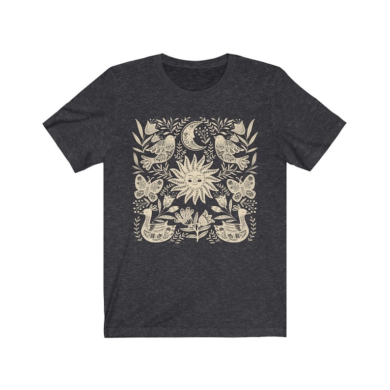 May include: A dark heather grey t-shirt with a cream-colored sun, moon, birds, butterflies, and floral design.