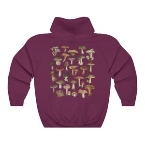 May include: Burgundy hoodie featuring a detailed illustration of various mushrooms in shades of brown, green, and red. The design is centered on the back of the hooded sweatshirt. The hoodie has a drawstring hood and a kangaroo pocket.