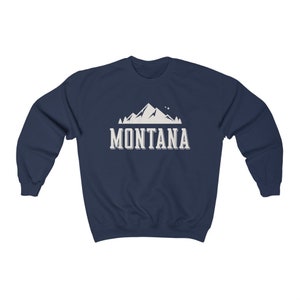 May include: Navy blue sweatshirt with a white mountain graphic and the text "MONTANA" in white.