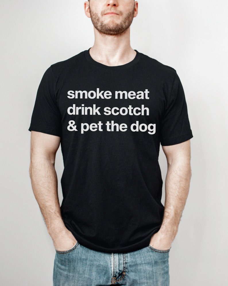 May include: A black t-shirt with white text that reads "smoke meat drink scotch & pet the dog".