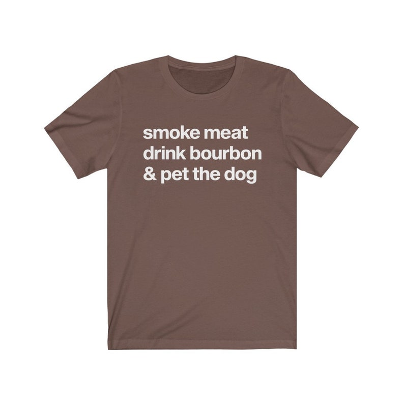 May include: A brown t-shirt with the text "smoke meat drink bourbon & pet the dog" printed in white.