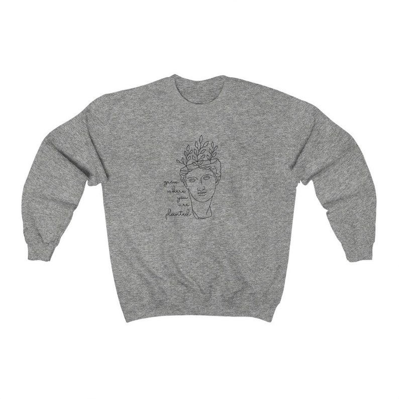 May include: Gray sweatshirt with a line drawing of a person with plants growing out of their head. The text "grow where you are planted" is below the drawing.