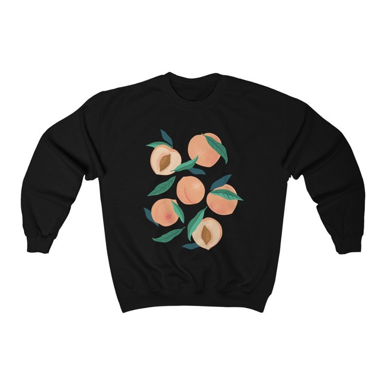 K&ouml;nnte beinhalten: Schwarzer Pullover mit einem Grafikdruck von Pfirsichen mit gr&uuml;nen Bl&auml;ttern.