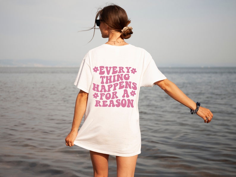 May include: White t-shirt with a pink graphic that says "*EVERY* THING HAPPENS *FOR A* REASON" on the back.
