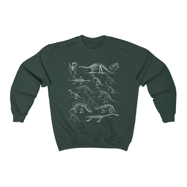 May include: A dark green sweatshirt with a white print of dinosaur skeletons. The print features a variety of dinosaurs, including a Stegosaurus, Triceratops, and Brachiosaurus.