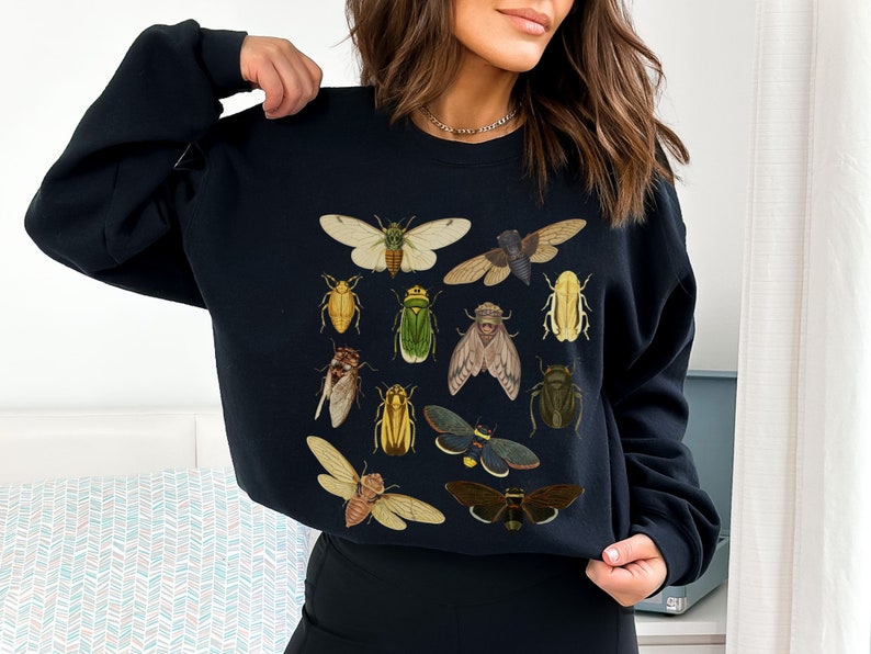 May include: Black sweatshirt with a graphic print of various insects, including beetles, butterflies, and moths.