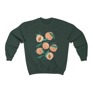 May include: A dark green sweatshirt with a graphic print of peaches and leaves. The peaches are a light peach color and the leaves are a light green color.