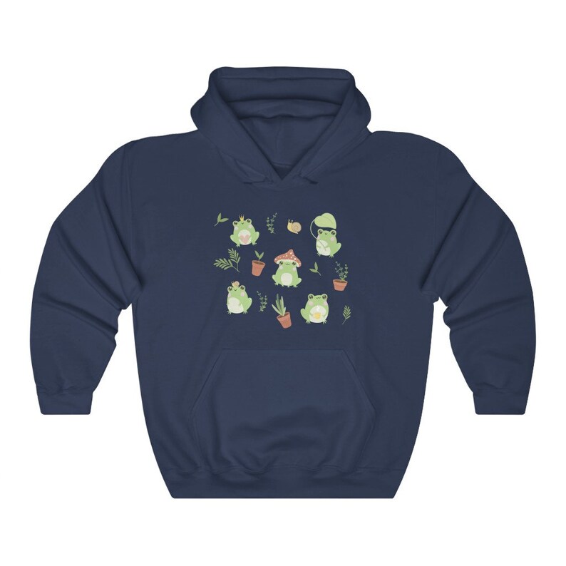 May include: A navy blue hoodie with a pattern of green frogs wearing different hats and accessories. The frogs are surrounded by small plants and flowers.