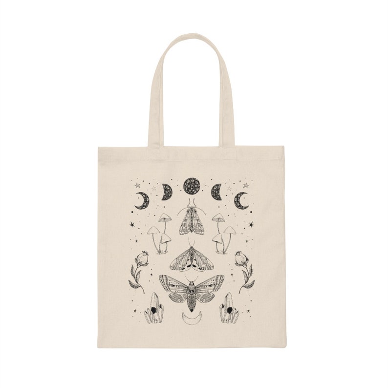 May include: A white canvas tote bag with a black and white design featuring moths, mushrooms, crystals, and moons.