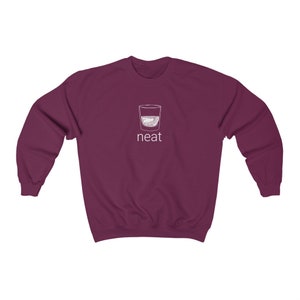 Pode incluir: Camisola de cor bord&ocirc; com um contorno branco de um copo de licor e a palavra "neat" impressa na frente.