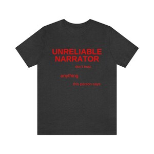 Puede incluir: Camiseta gris oscuro con el texto "UNRELIABLE NARRATOR" en rojo. El texto "don't trust anything this person says" tambi&eacute;n est&aacute; en rojo.