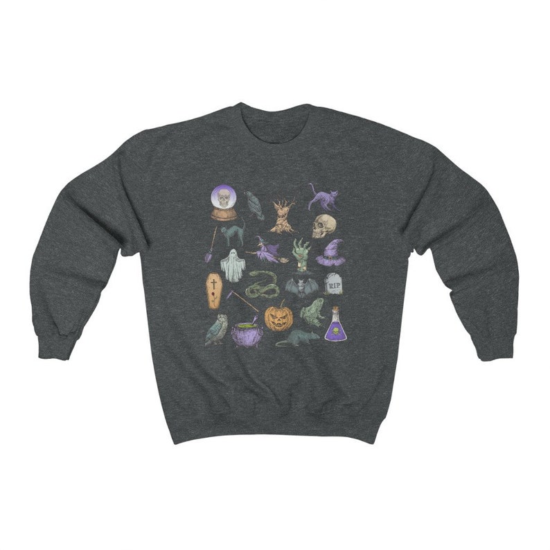 May include: A dark heather grey sweatshirt with a colorful graphic print of various Halloween-themed icons, including a skull, a cauldron, a ghost, a bat, a pumpkin, a cat, a snake, a spider, a witch's hat, a tree, a crow, a potion bottle, a crystal ball, a broom, a coffin, and a tombstone.