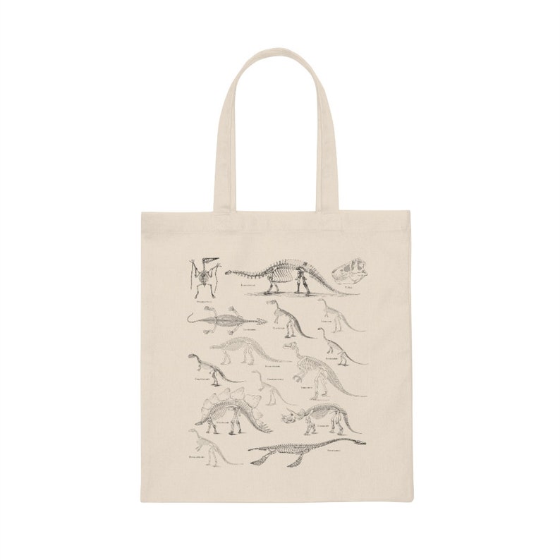 May include: A beige tote bag with a black and white illustration of dinosaur skeletons. The illustration includes a variety of dinosaurs, including a Stegosaurus, a Triceratops, and a Brachiosaurus.