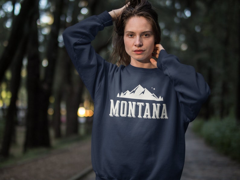 May include: A navy blue sweatshirt with a white mountain graphic and the text "MONTANA" in white.