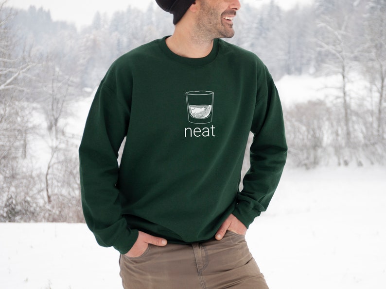 Pode incluir: Uma camisa de frio verde escura com um gr&aacute;fico branco de um copo de &aacute;gua e a palavra "neat" impressa na frente.