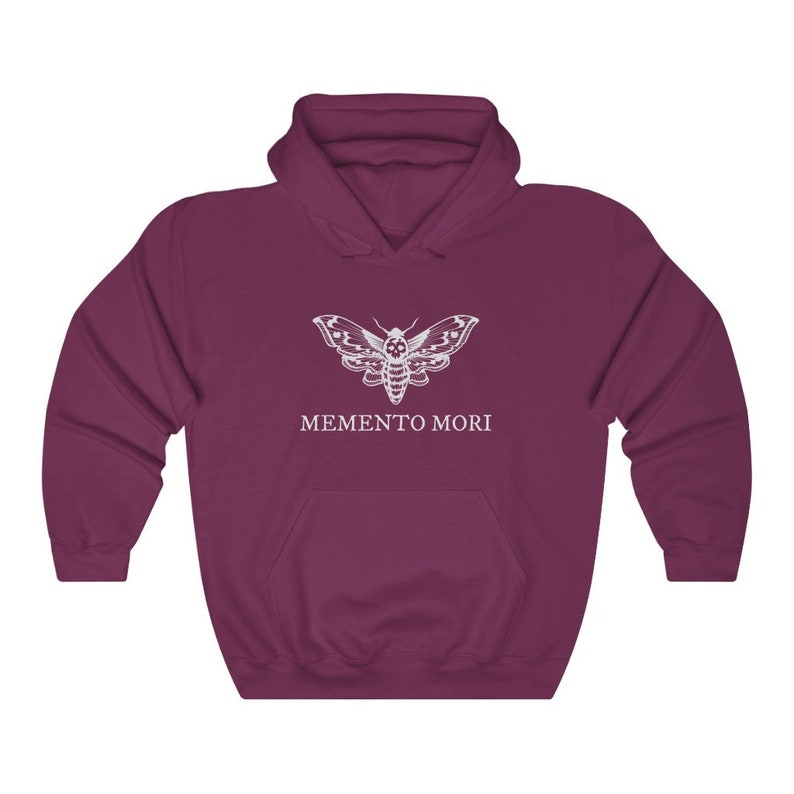 K&ouml;nnte beinhalten: Ein maroonfarbener Kapuzenpullover mit einem wei&szlig;en Motiv eines Motten mit einem Totenkopf auf dem Kopf und dem Text "MEMENTO MORI" darunter.