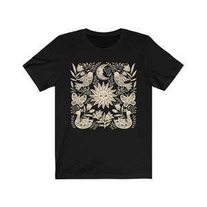 May include: Black t-shirt with a white sun, moon, birds, butterflies, and floral design.