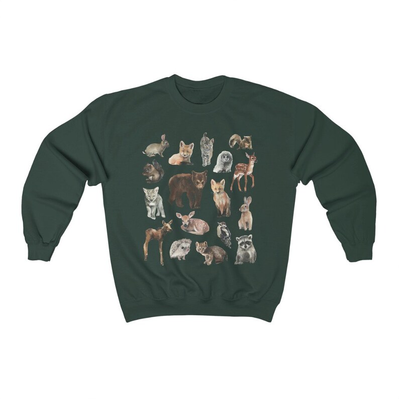 May include: A dark green sweatshirt featuring a pattern of various woodland animals, including a fox, bear, deer, raccoon, and owl. The animals are illustrated in a watercolour style.