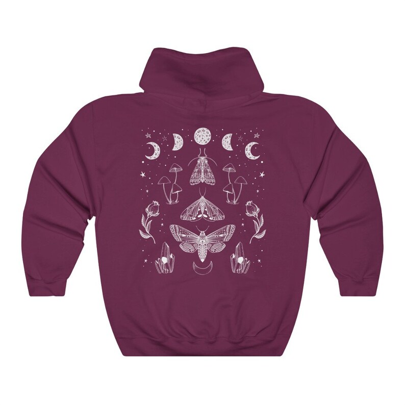 Pu&ograve; includere: Una felpa con cappuccio color granata con un design grafico bianco che presenta una falena, funghi e lune. Il design &egrave; centrato sulla felpa.