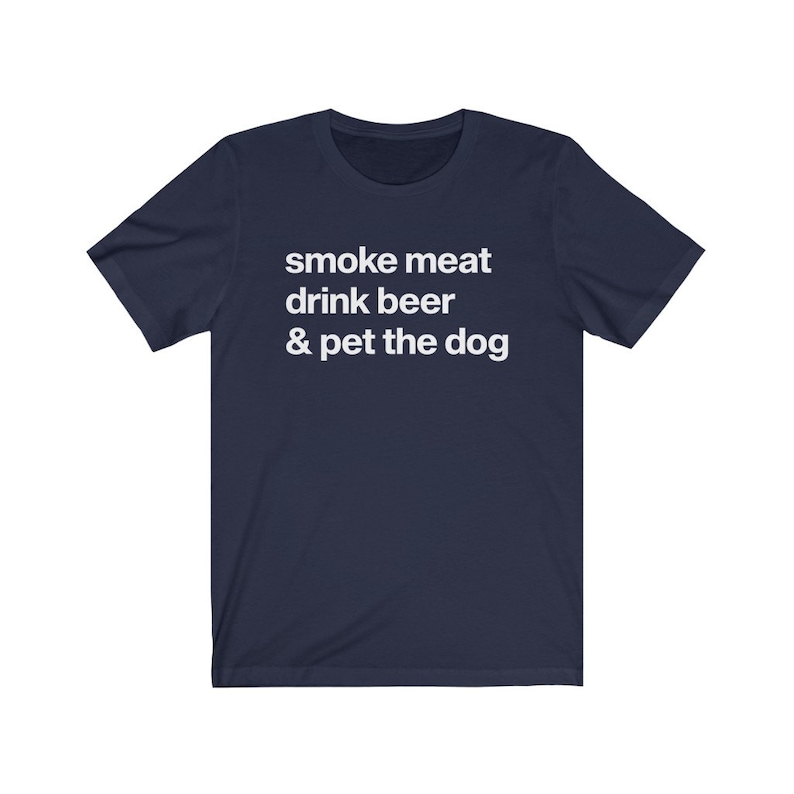 K&ouml;nnte beinhalten: Ein marineblaues T-Shirt mit wei&szlig;em Text, der "smoke meat drink beer & pet the dog" lautet.