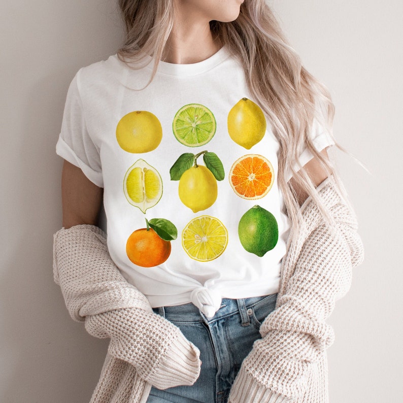 Pode incluir: Camiseta branca com um gr&aacute;fico de nove frutas c&iacute;tricas, incluindo lim&otilde;es, limas, laranjas e toranjas. As frutas est&atilde;o dispostas em uma grade na camiseta.