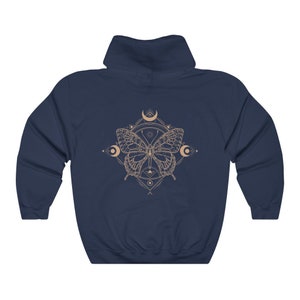 May include: Navy blue hooded sweatshirt with a graphic of a butterfly with geometric patterns and moons in a light brown color.