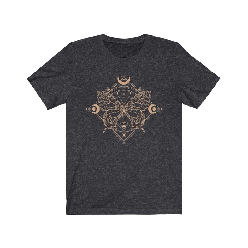 May include: A dark heather grey t-shirt with a graphic of a butterfly inside a geometric design. The butterfly is a light brown color and the geometric design is a light gold color.