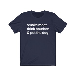 May include: Navy blue t-shirt with white text that reads "smoke meat drink bourbon & pet the dog".