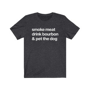 May include: A dark heather grey t-shirt with the text "smoke meat drink bourbon & pet the dog" printed in white.