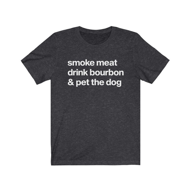 May include: A dark heather grey t-shirt with the text "smoke meat drink bourbon & pet the dog" printed in white.
