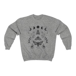 May include: A heather grey sweatshirt with a black and white graphic print of moths, mushrooms, and crescent moons. The graphic is centered on the front of the sweatshirt.