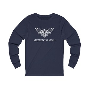 May include: Navy blue long-sleeved t-shirt with a white moth graphic and the text "MEMENTO MORI" printed on the front.