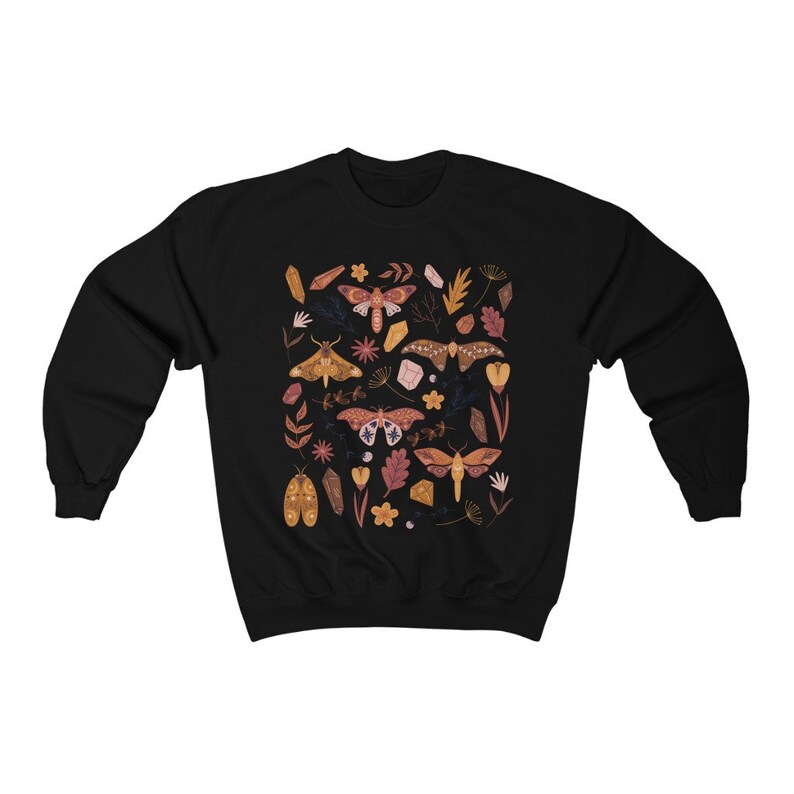 Puede incluir: Sudadera negra con un patr&oacute;n colorido de polillas, cristales y flores. El dise&ntilde;o presenta una variedad de especies de polillas, incluyendo polillas luna, polillas cecropia y polillas io.