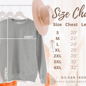 May include: Size chart for a grey sweatshirt with measurements in inches for chest and length. Sizes range from S to 4XL. The chart includes the text "GILDAN 18000 HEAVY BLEND SWEATSHIRT".