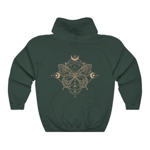 May include: A dark green hooded sweatshirt with a graphic print of a butterfly with geometric patterns and crescent moons in a beige color.