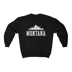 May include: Black sweatshirt with a white mountain graphic and the text "MONTANA" in a white vintage font.