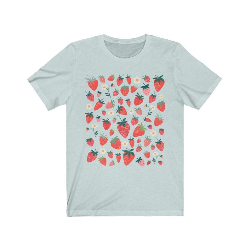 K&ouml;nnte beinhalten: Ein hellblaues T-Shirt mit einem Muster aus roten Erdbeeren und wei&szlig;en Bl&uuml;ten.