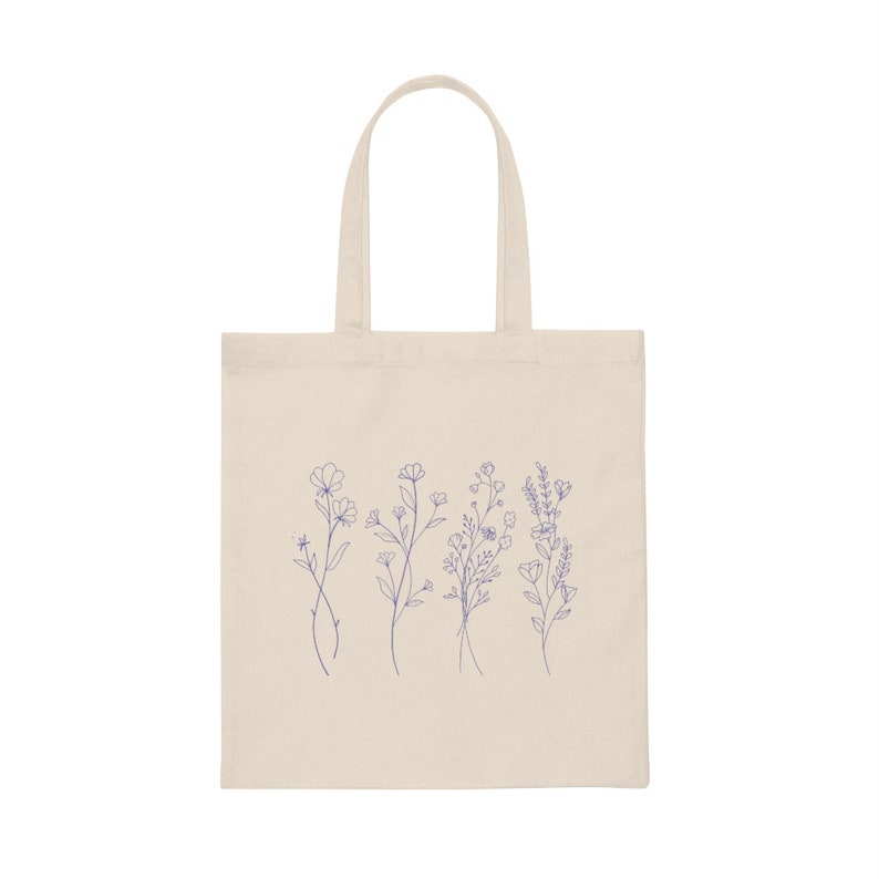 May include: A natural canvas tote bag with a design of five blue line drawings of different wildflowers.