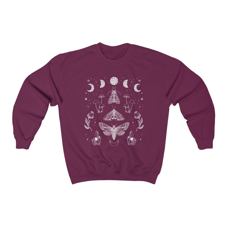 May include: A maroon sweatshirt with a white graphic design featuring moths, mushrooms, and crescent moons.