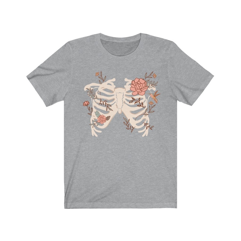 May include: A gray t-shirt with a white ribcage design surrounded by pink flowers and green leaves. A small orange hummingbird is perched on a branch.