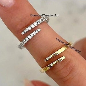 May include: Two gold rings with a minimalist design. The top ring is set with small clear stones and the bottom ring is plain.