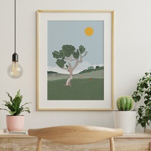 May include: A framed illustration of a stylized tree with a yellow sun in a blue sky. The tree is green and brown and is set against a green field with a brown hill in the background.
