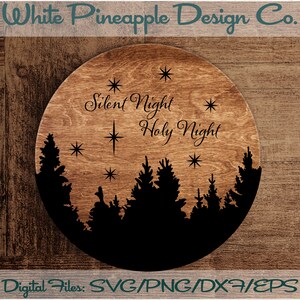 May include: A round wooden sign with a black silhouette of a forest and the text "Silent Night Holy Night" in a cursive font.