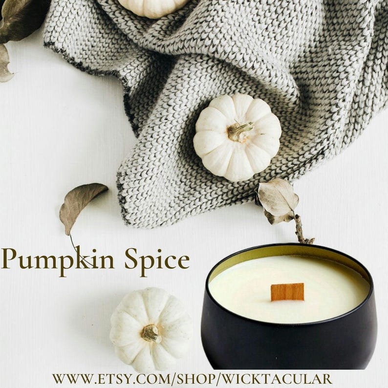 May include: A black candle with a wooden wick in a glass jar with a gold rim. The candle is on a white surface with a gray knitted blanket and white pumpkins. The text "Pumpkin Spice" is written in black letters on the white surface. The text "WWW.ETSY.COM/SHOP/WICKTACULAR" is written in black letters on the white surface.